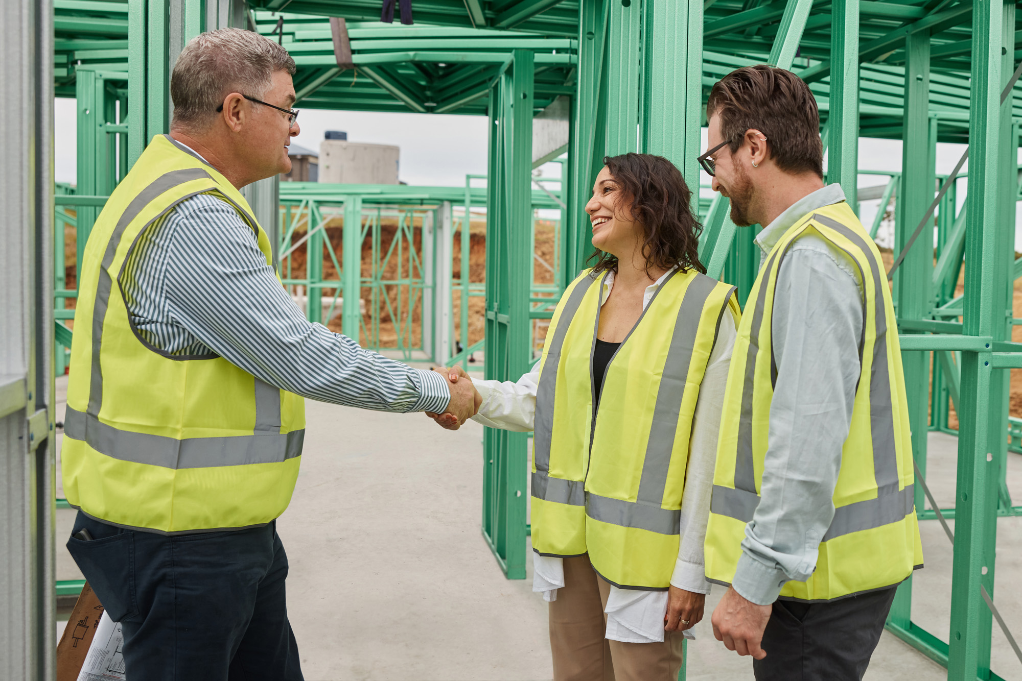 couple on site with agent shaking hands